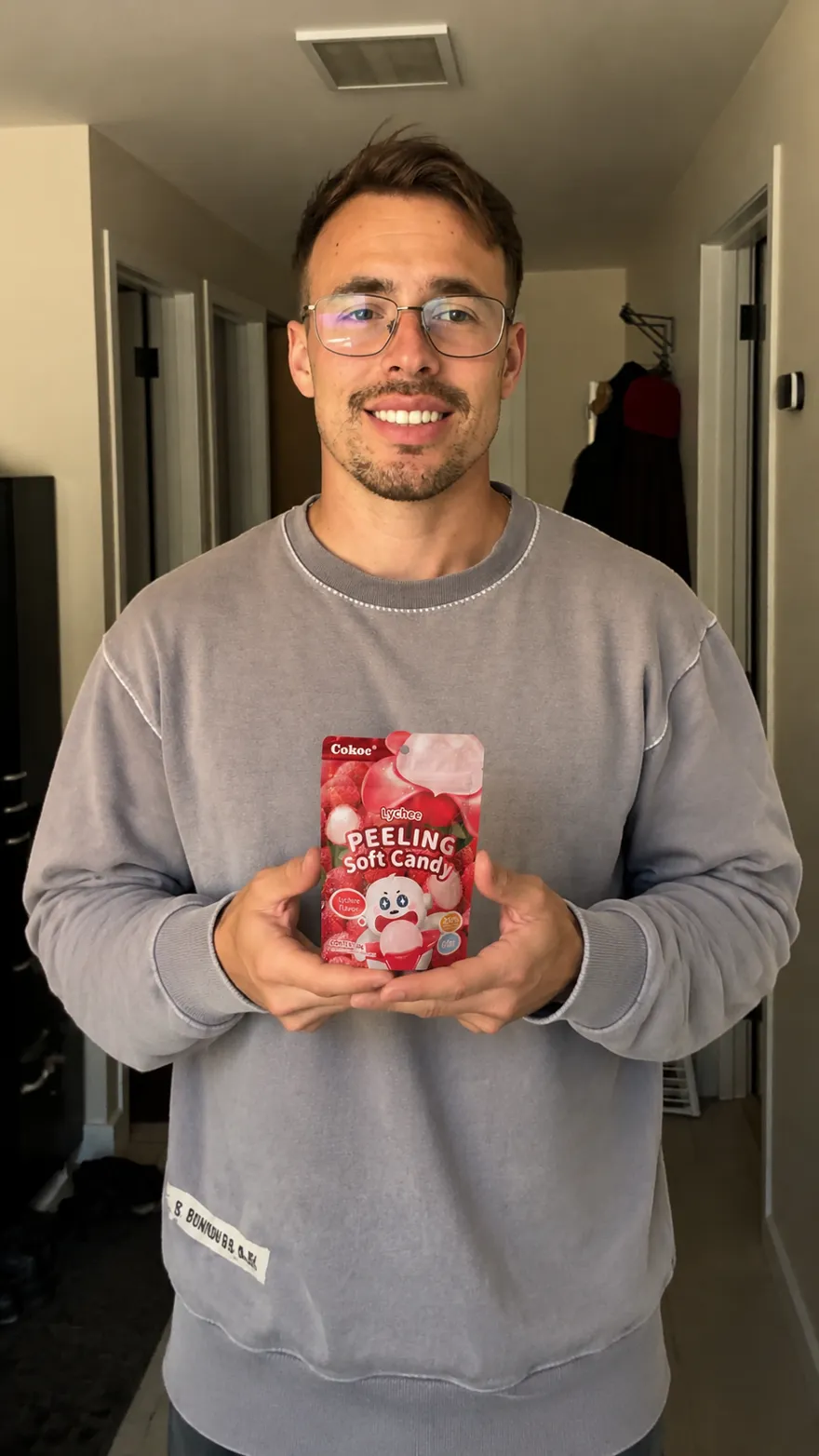Jemand hält eine Packung Lychee-Fruchtgummi ins Bild